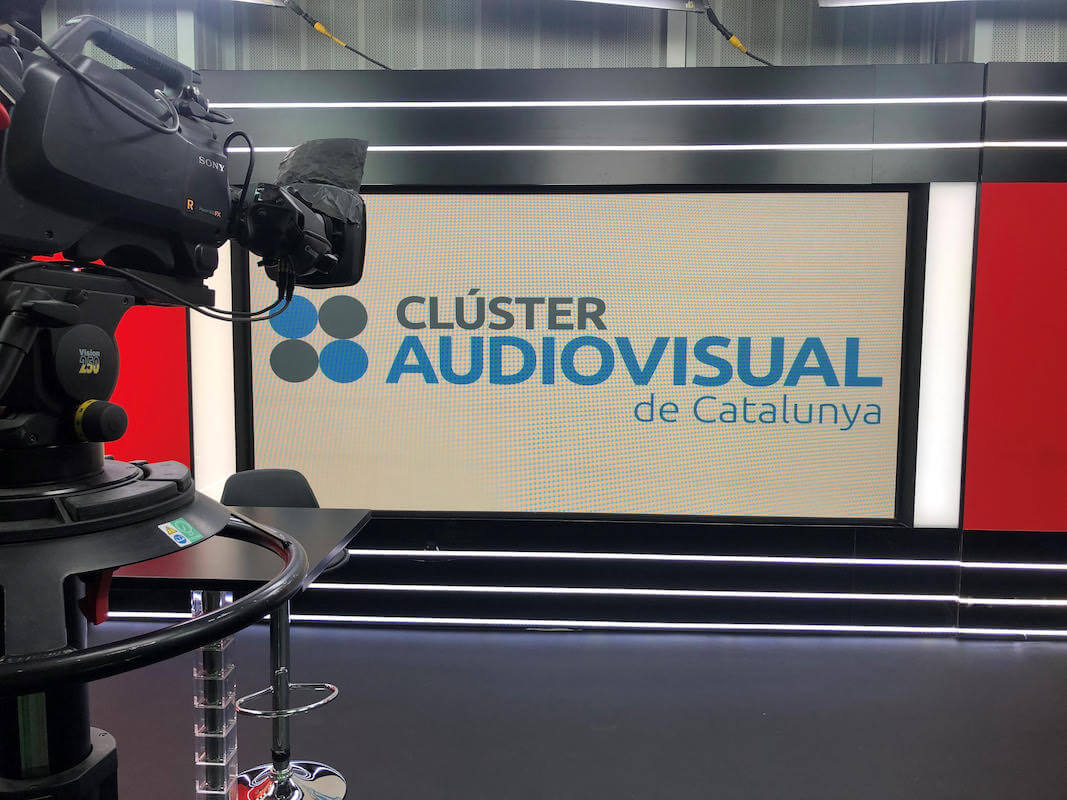 Pantalla amb el logo del Clúster Audiovisual de Catalunya i una càmera a l'esquerra
