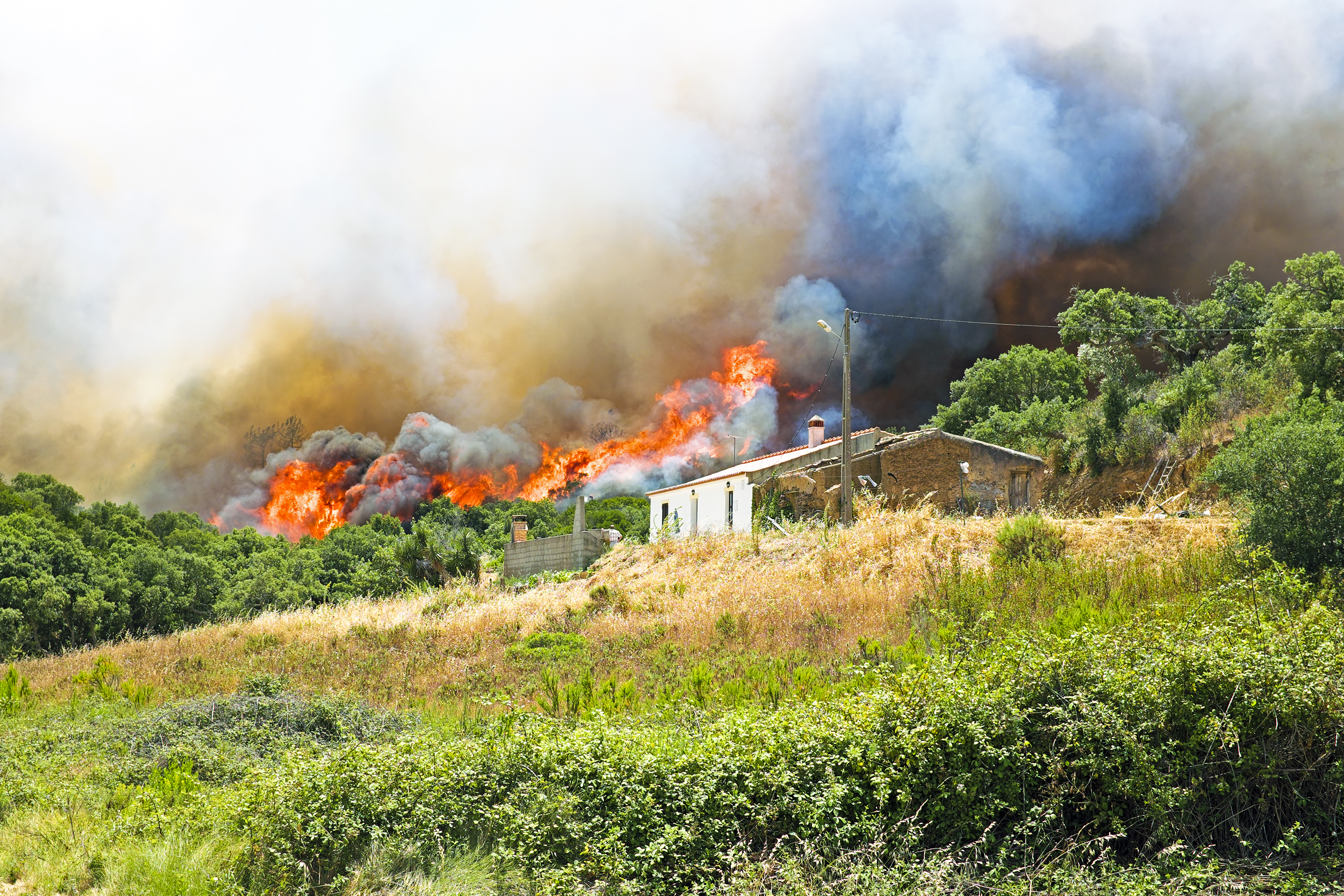Una casa amb un foc a darrere.