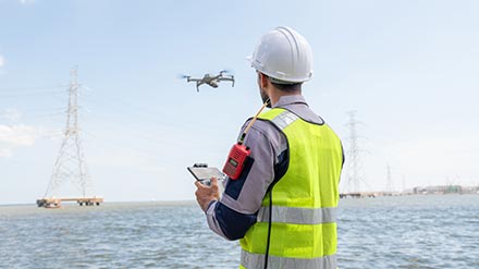 Dos treballadors a la carretera emprant un dron