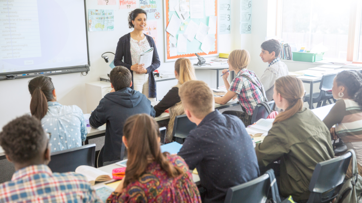 Imatge d'una classe d'universitat amb la professora i l'alumnat