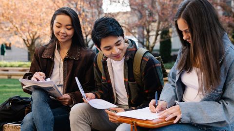 Tres estudiants repassant a l'exterior