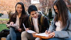 Tres estudiants repassant a l'exterior