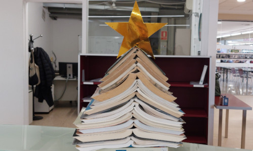 Un arbre de Nadal fet amb llibres oberts i amuntegats 