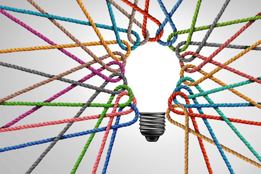 Image of a light bulb made of intertwined colorful ropes, symbolizing collaboration, idea connectivity, and diversity in teamwork.