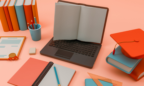 An open laptop and several books organised on a desk