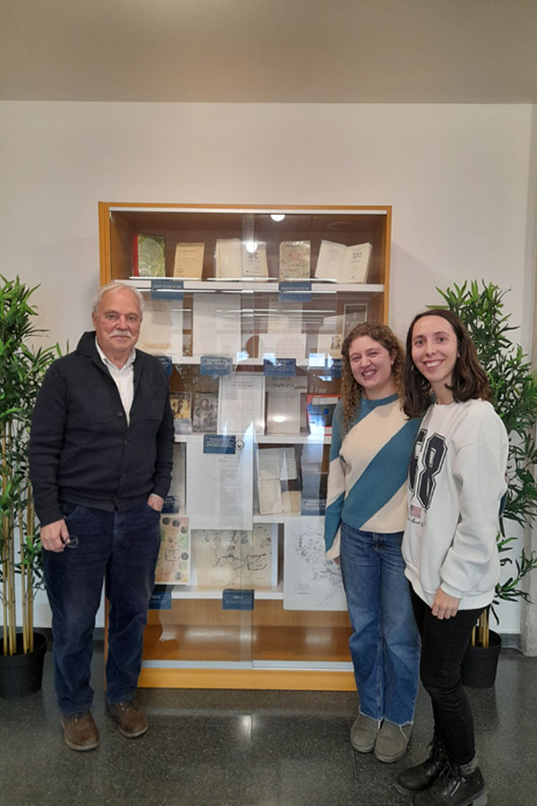 The two student interns and Francesc Parcerisas in front of the display case where part of the Francesc Parcerisas Collection is exhibited.